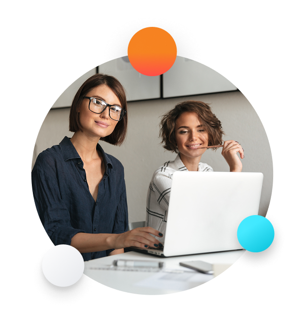 two-young-happy-women-working-by-table two-young-happy-women-working-by-table